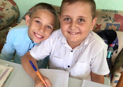 Boys doing school work together smiling